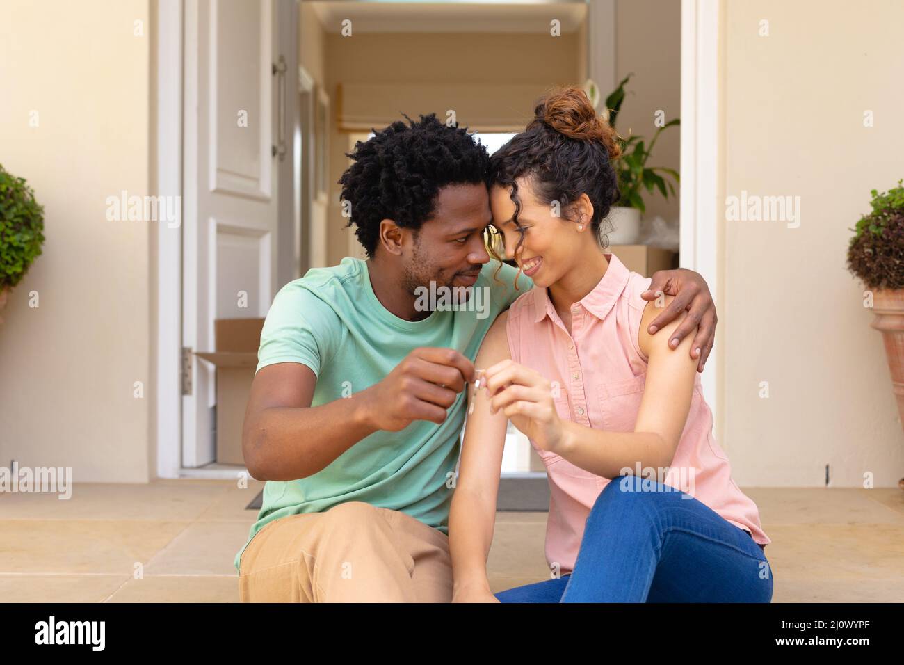 Happy young multiracial couple holding new house keys while sitting ...