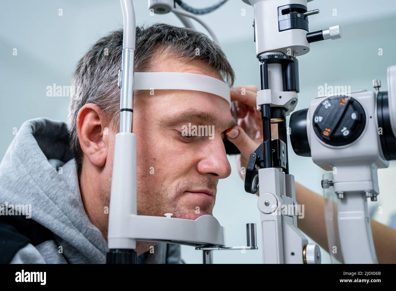 Optometrist examining the eyes of a male patient in a modern ophthalmology clinic. Eye doctor with man patient during an examina Stock Photo