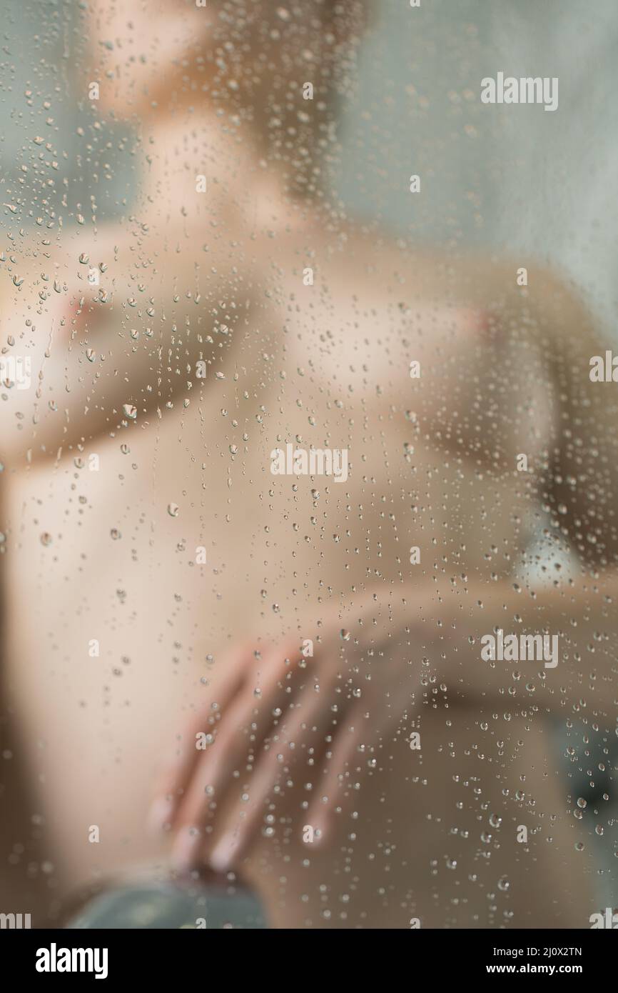 Naked woman washing in shower cabin in bathroom Stock Photo