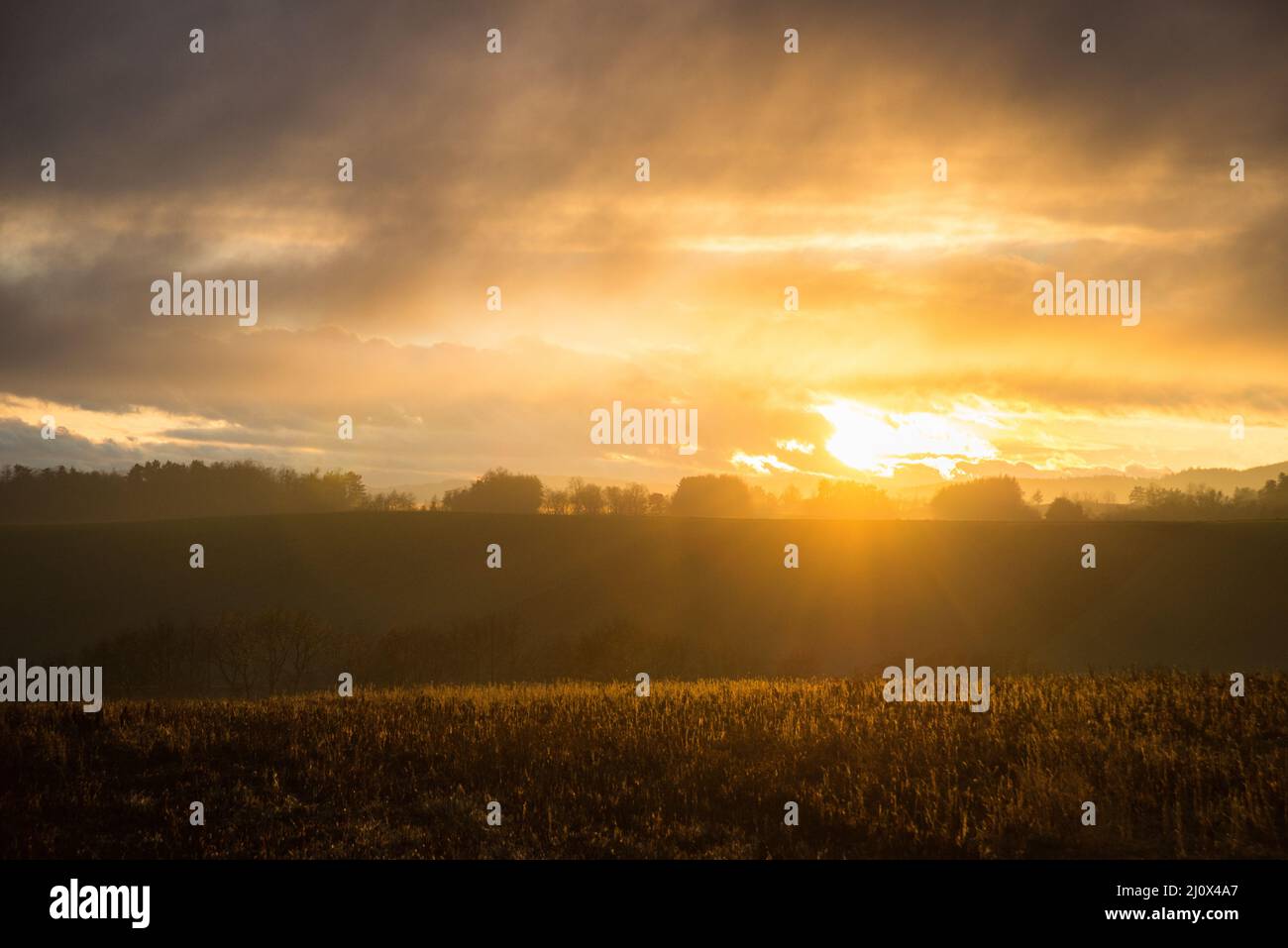 Sunset with dramatic clouds and moody light Stock Photo - Alamy