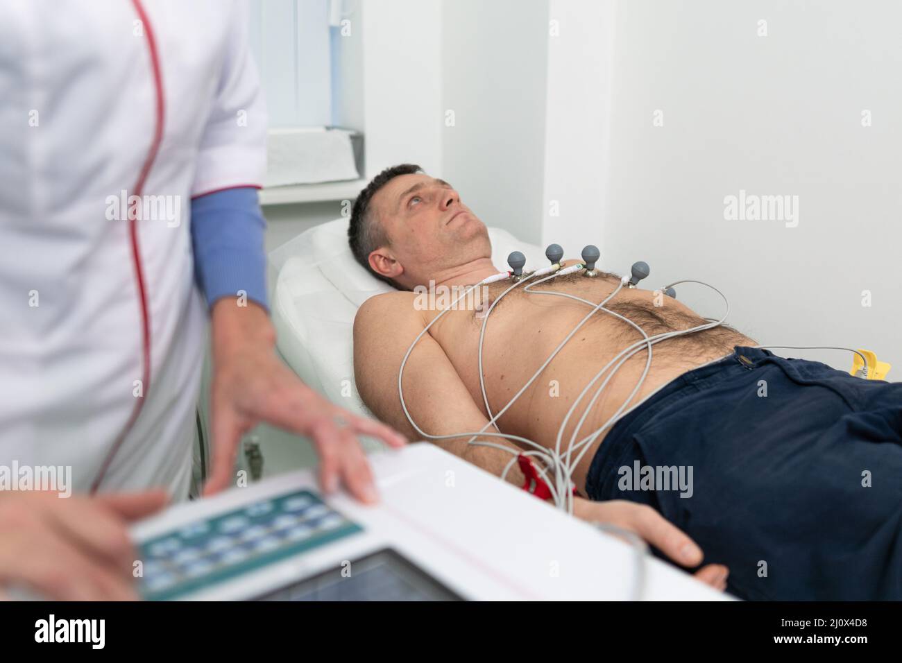 Medical equipment for electrocardiogram. Doctors doing ECG test on male patient. Diagnostic heart disease heart attack, tachycar Stock Photo