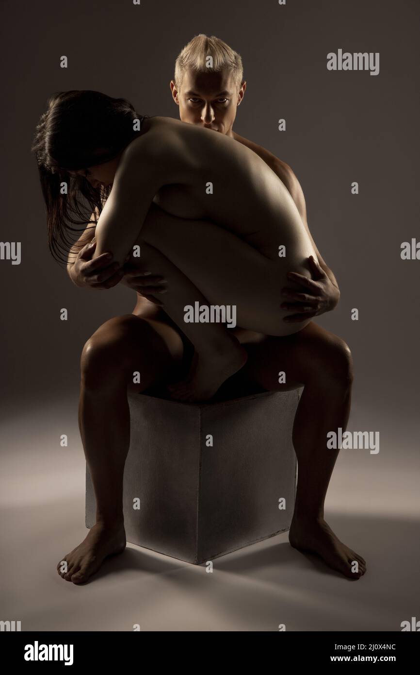 Naked man embracing sensual woman in studio Stock Photo