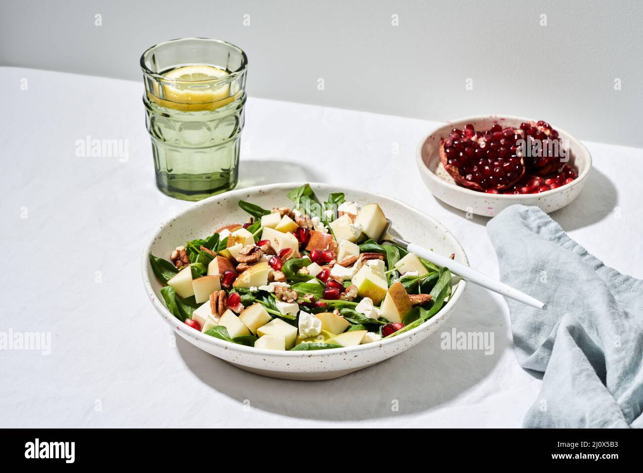 Hard light, Fruits salad with nuts, balanced food, clean eating. Spinach with apples Stock Photo