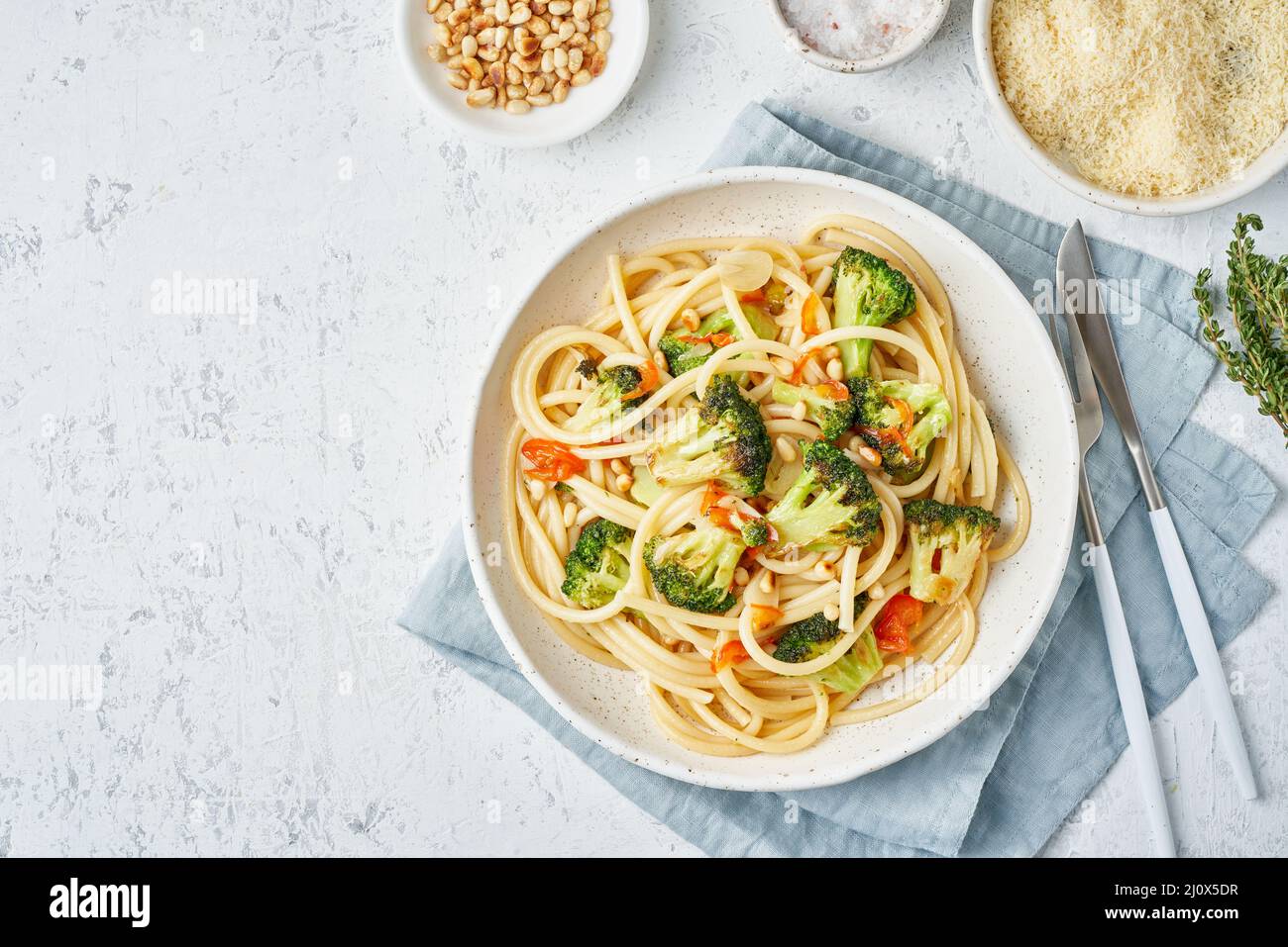 Spaghetti pasta with broccoli, bucatini with pine nuts. Food for vegans, vegetarians Stock Photo
