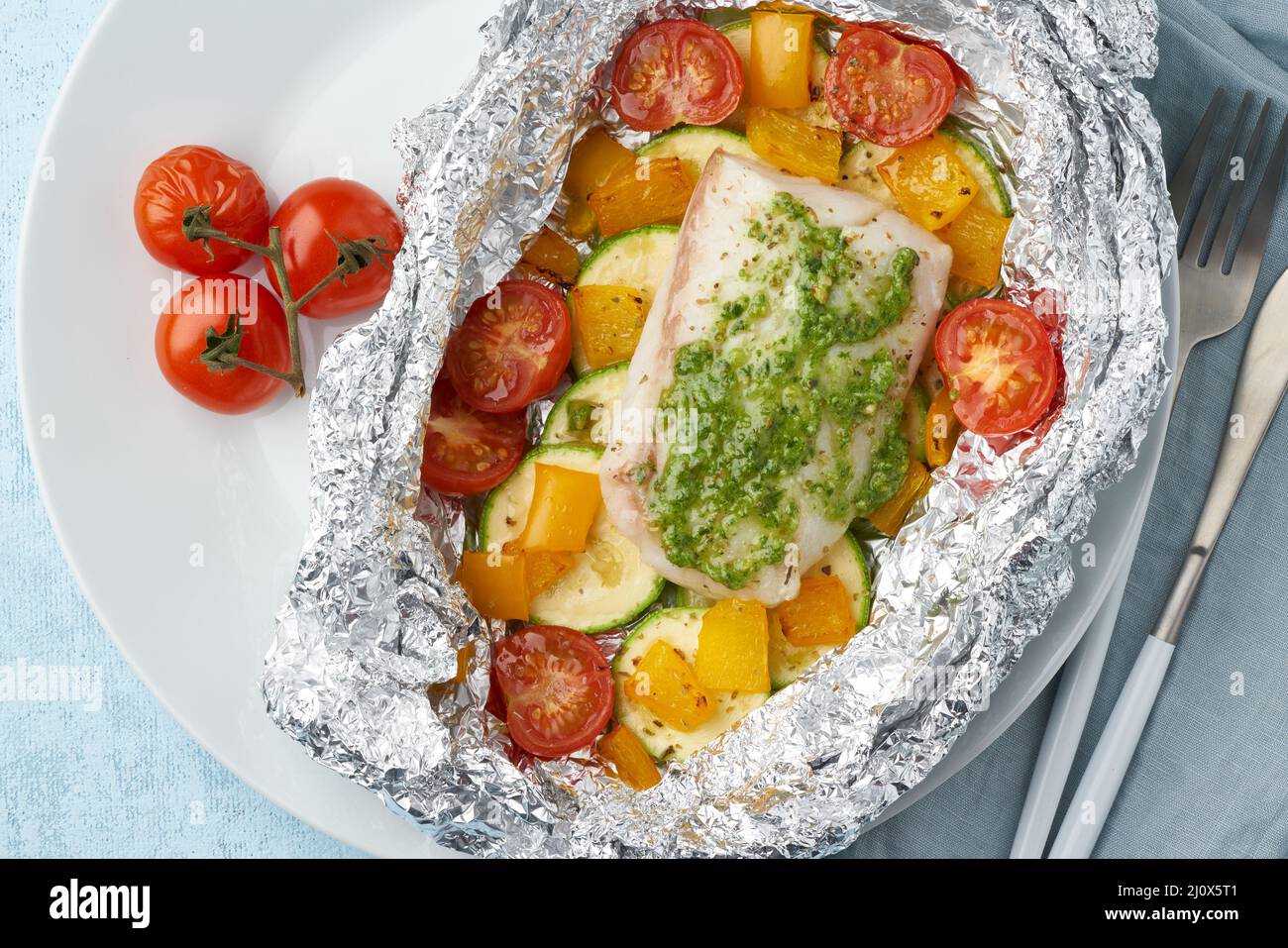 Foil pack dinner with white fish. Oven baked fillet of cod, pike perch