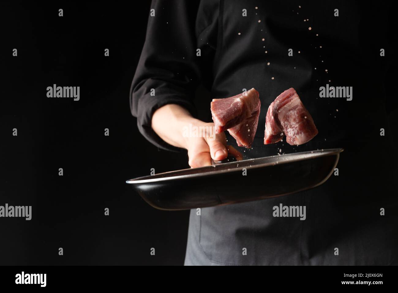 The chef prepares steaks from meat, pork or beef, throwing fresh meat