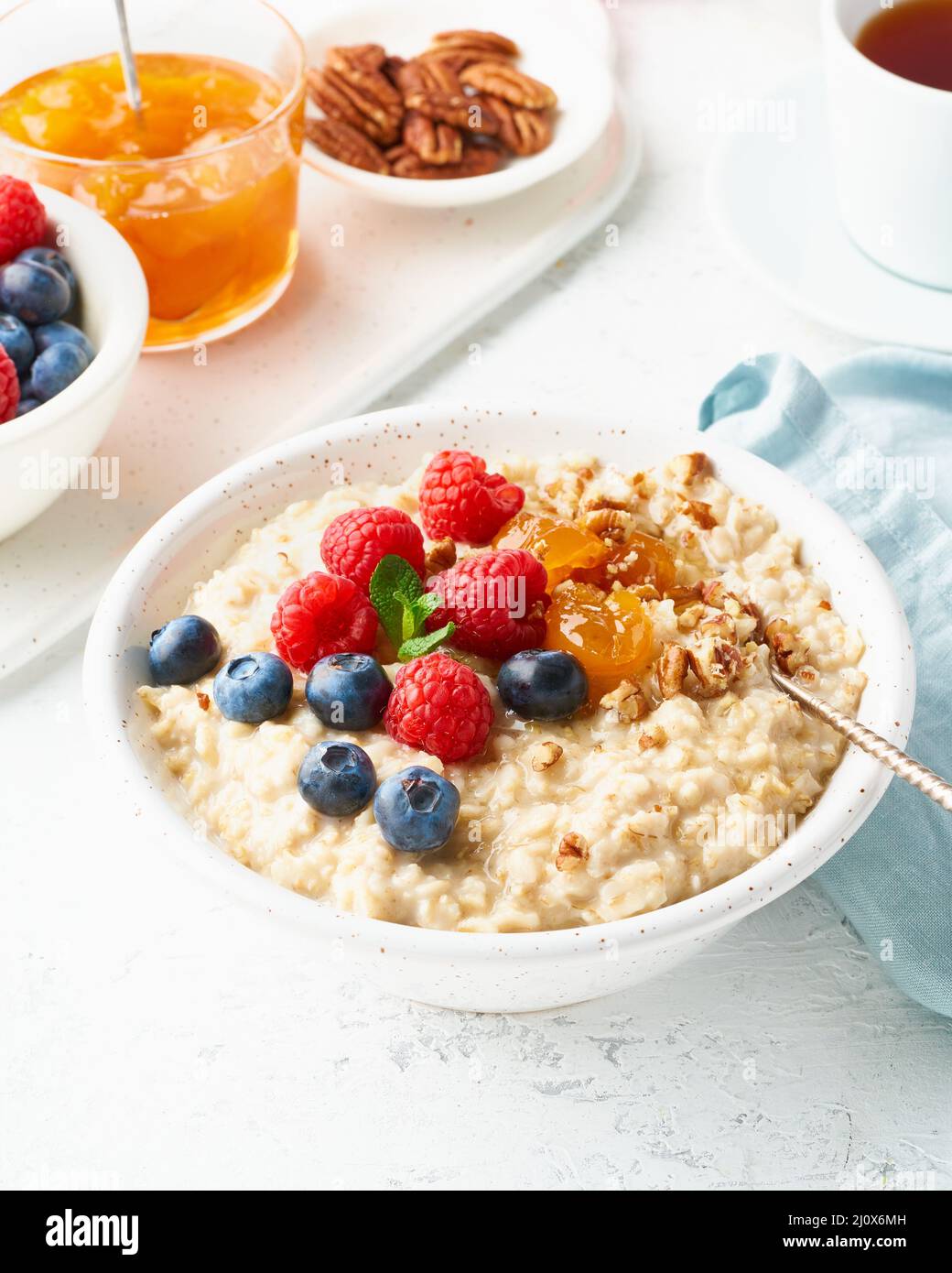 Oatmeal porridge with blueberry, raspberries, side view, close up, vertical, breakfast with berries Stock Photo