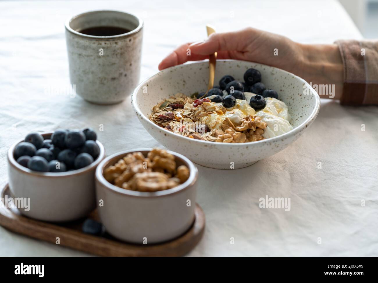 Eating healthy lifestyle breakfast with granola muesli and yogurt in bowl on white table Stock Photo