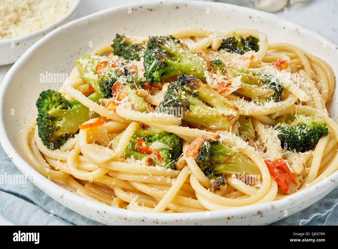 Spaghetti pasta with broccoli, bucatini with pine nuts. Food for vegans, vegetarians Stock Photo