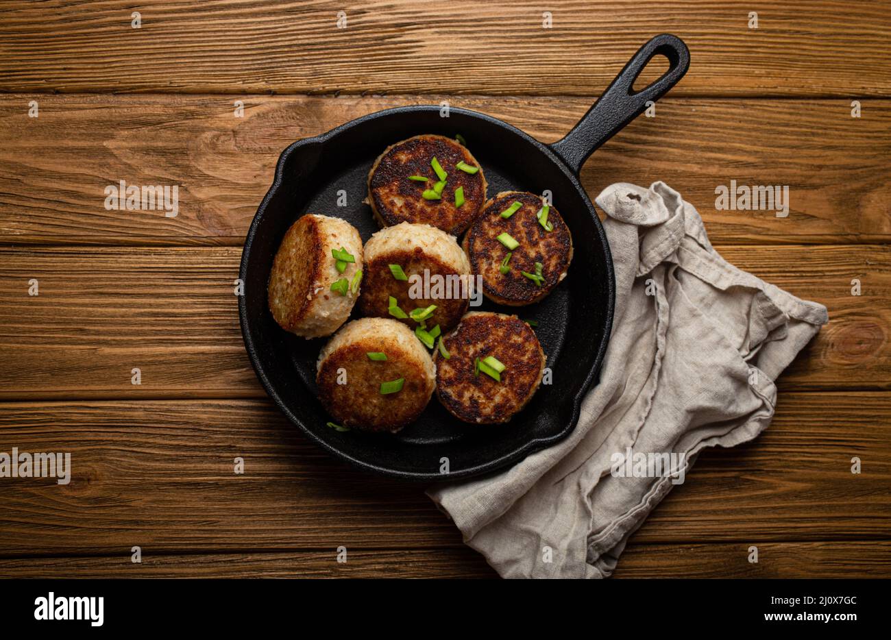 Homemade cutlets from fish, chicken or meat on black cast iron frying