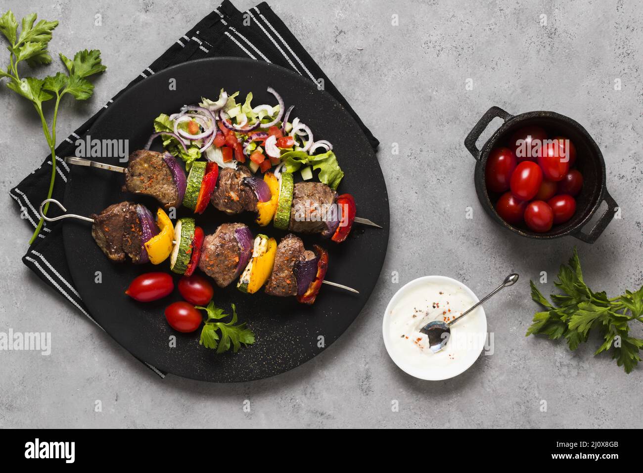 Delicious arabic fast food skewers black plate tomatoes. High quality photo Stock Photo