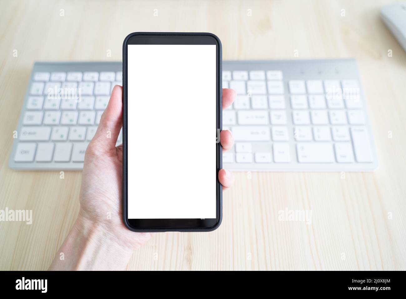 Unrecognizable person hold cell phone. View from behind, mockup with white phone display Stock Photo