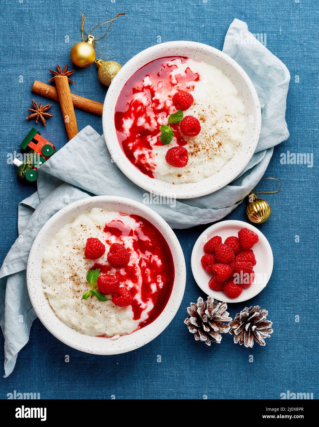 Rice pudding. Christmas food. French milk rice dessert with raspberries. Dark background, vertical Stock Photo