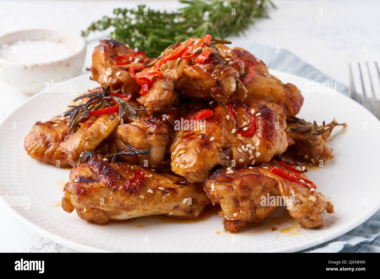Barbecue chicken wings. Oven baked chiken on plate. Hot korean food. Side view, close up Stock