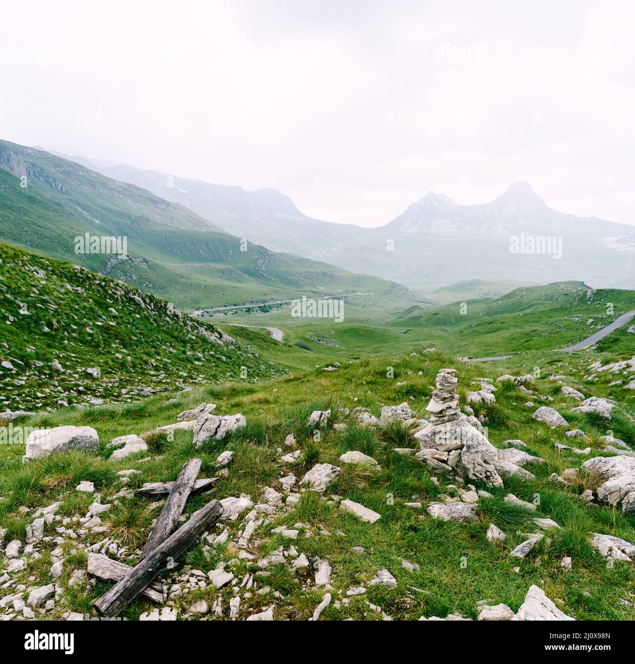 Rocks in a valley with mountains in fog in the background in Durmitor National Park Stock Photo