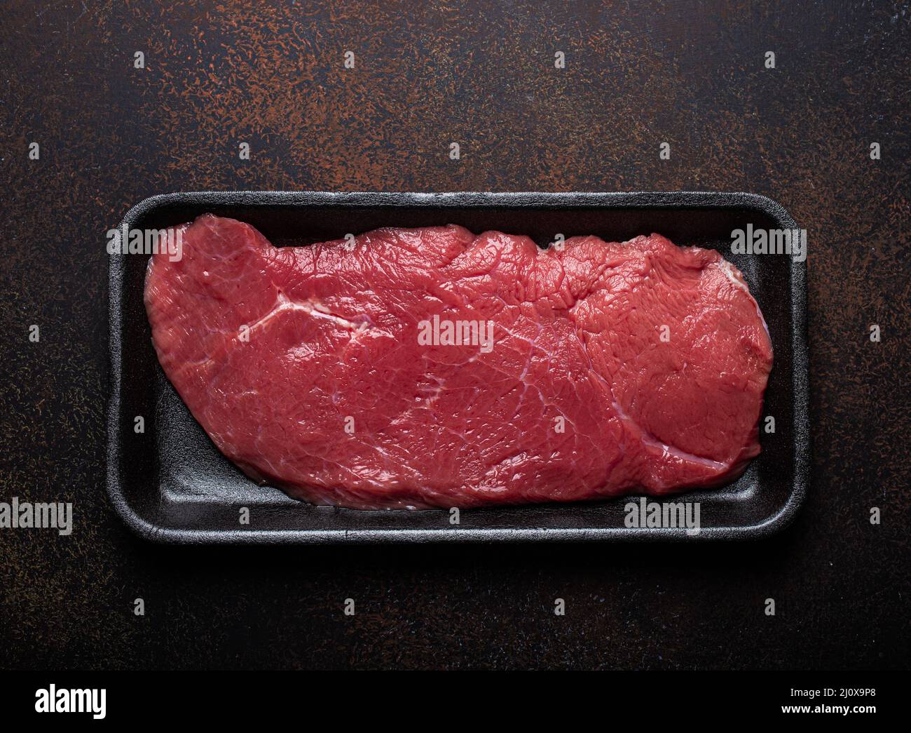 Beef lean raw fillet steak in black plastic container Stock Photo