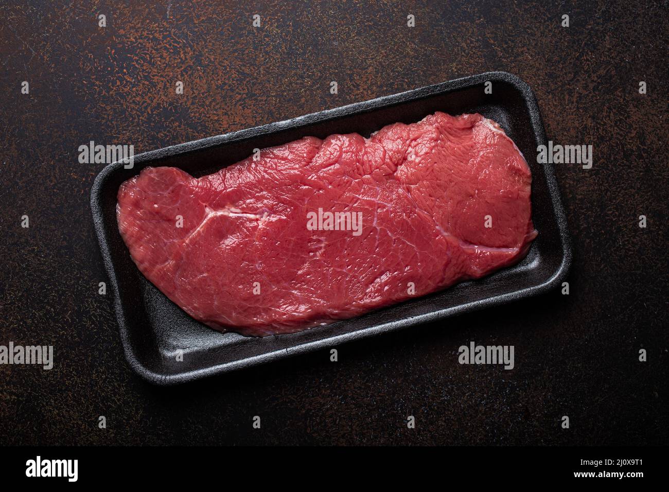 Beef lean raw fillet steak in black plastic container Stock Photo