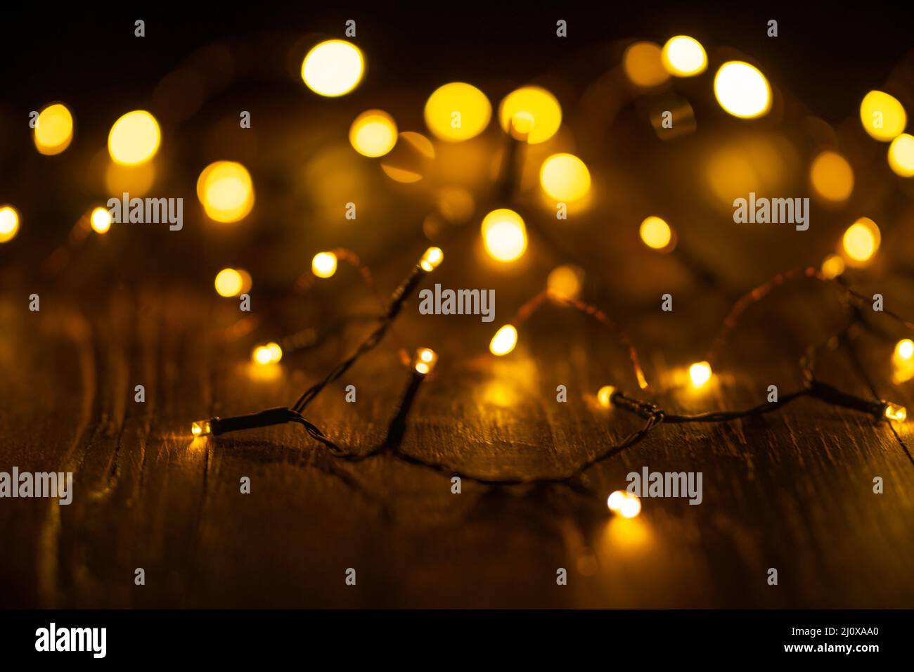 Garland in the unfocus. Holiday Glowing Background. Defocused background with blinking stars. Blurred bokeh. Stock Photo