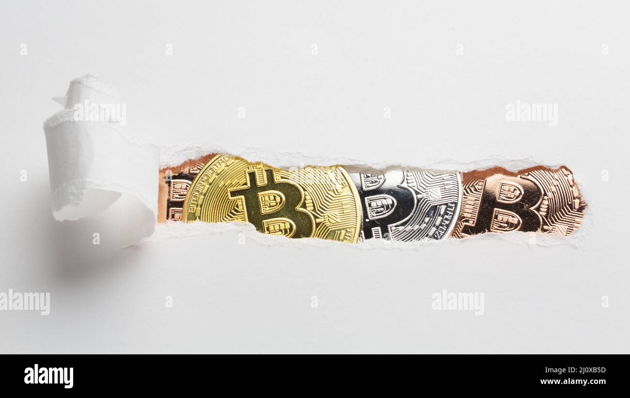 Ripped paper revealing bitcoin. High quality photo Stock Photo