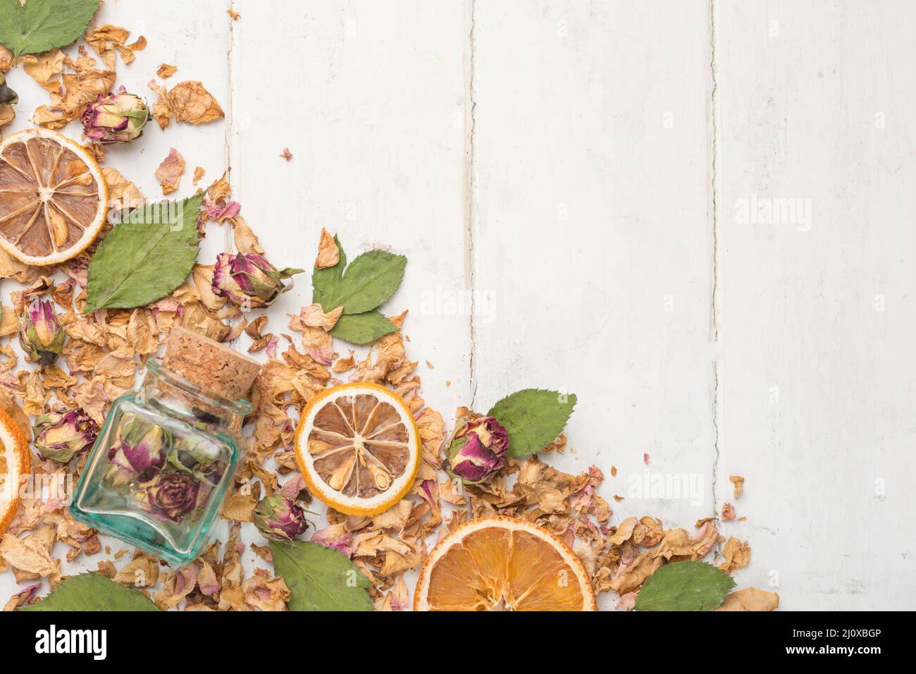 Dried roses and roses in a glass jar with dried oranges. The concept of