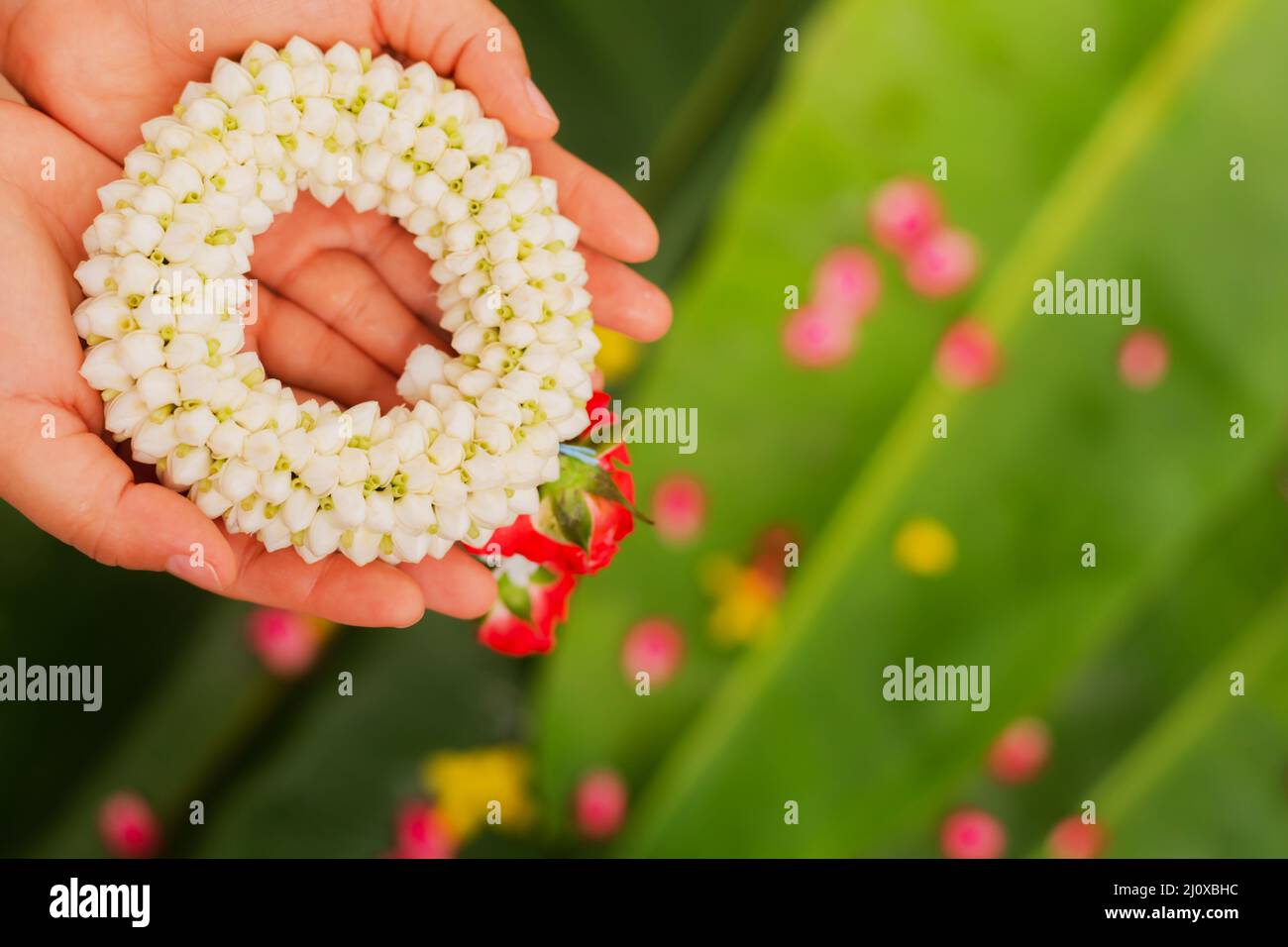 Mother's hand holding a jasmine garland during Songkran Festival Stock Photo