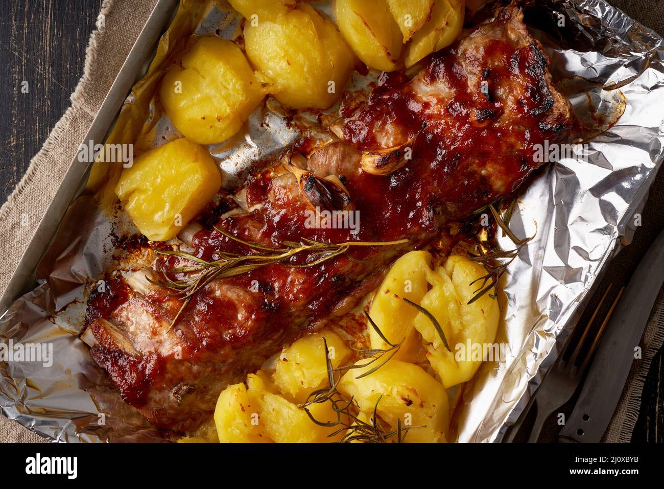 Spicy barbecue pork ribs and crushed smashed potatoes. Slow cooking recipe. Stock Photo