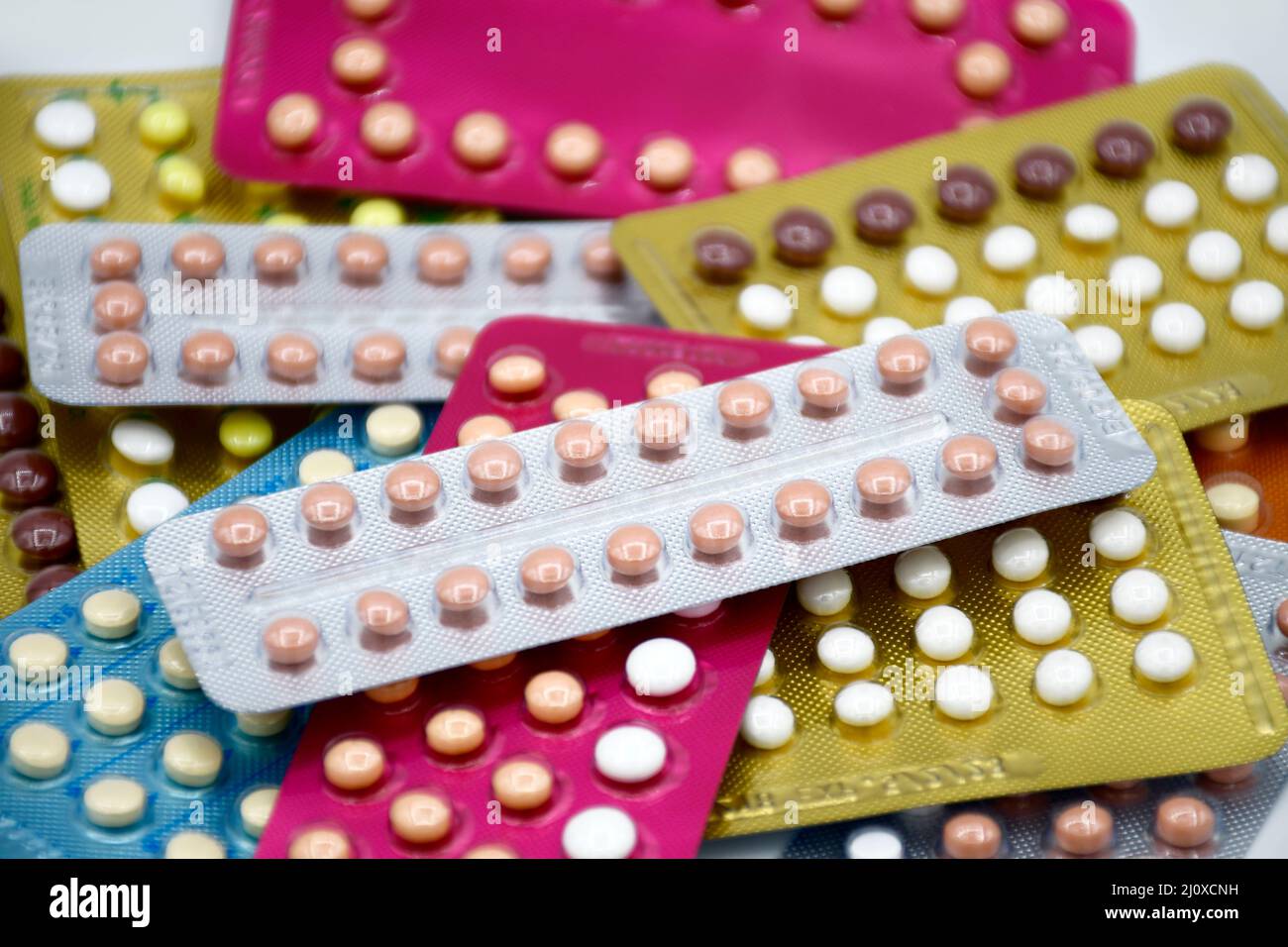 Oral contraceptive pill on pharmacy counter with colorful pills strips background. Stock Photo