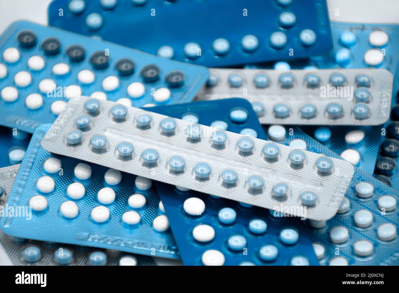 Oral contraceptive pill on pharmacy counter with colorful pills strips background. Stock Photo