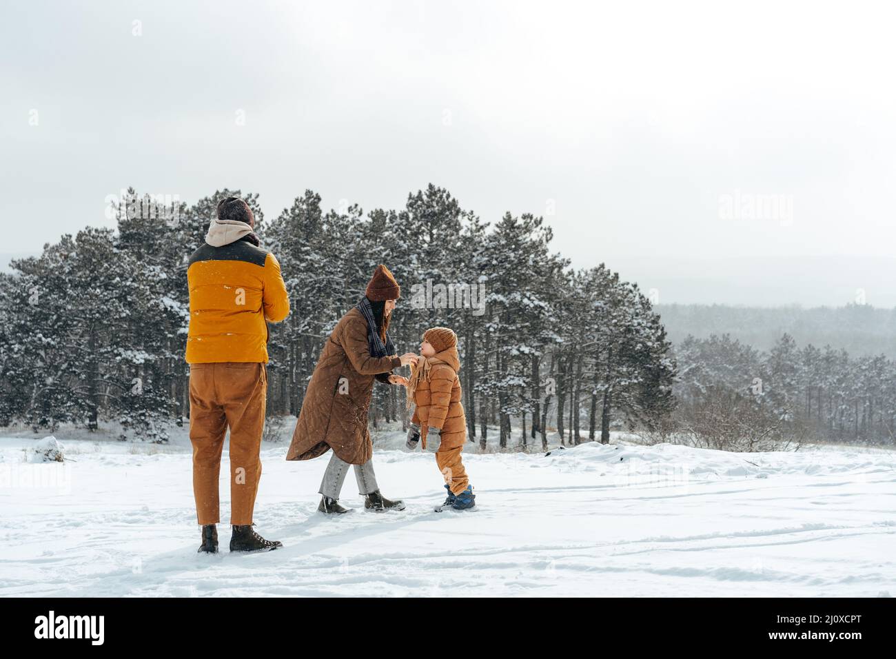 Happy family having a walk in winter outdoors in snow Stock Photo - Alamy