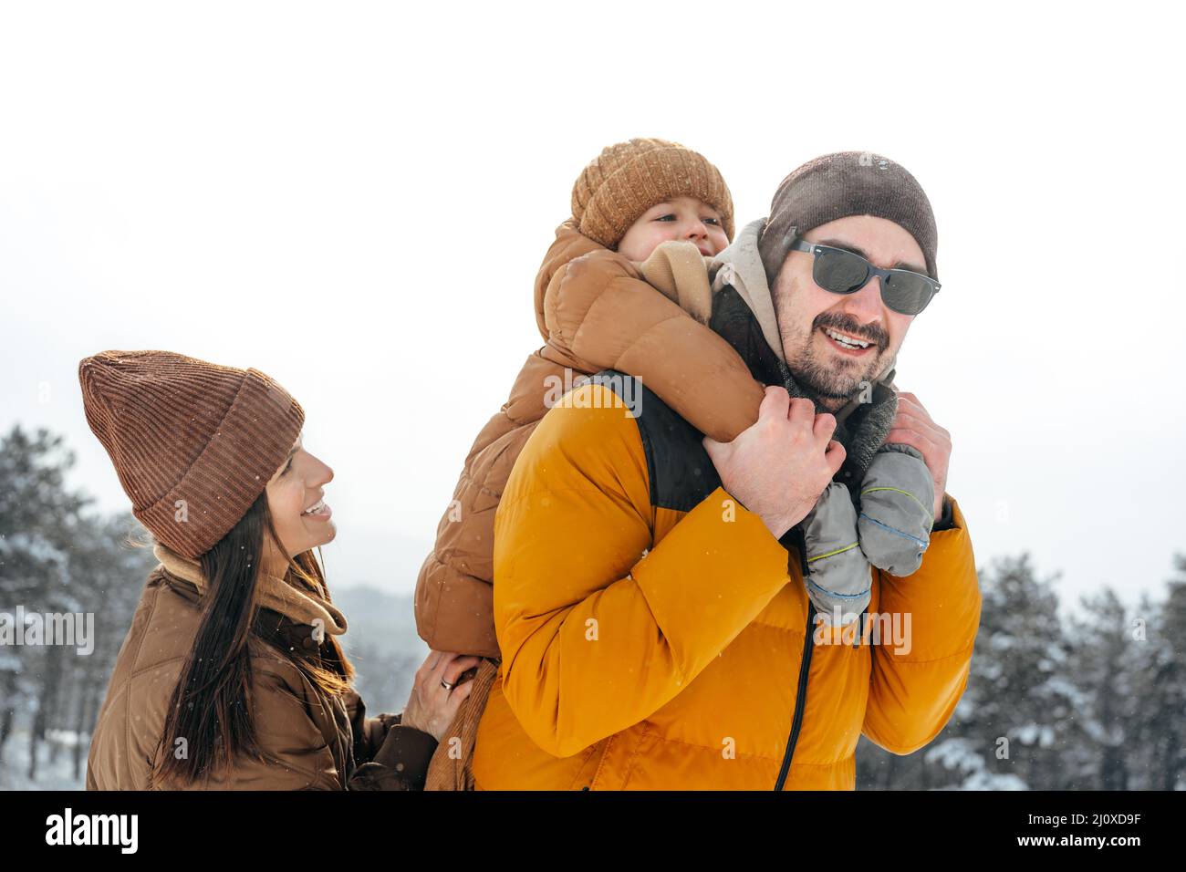 Happy family having a walk in winter outdoors in snow Stock Photo - Alamy