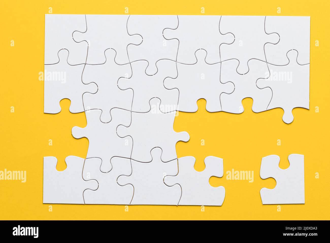 White cardboard jigsaw puzzles yellow background. High quality photo Stock Photo