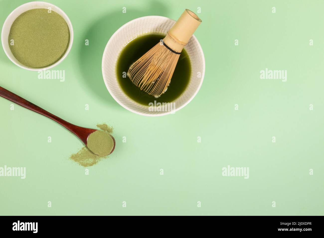 melting matcha green tea powder in water to make green tea drink Stock