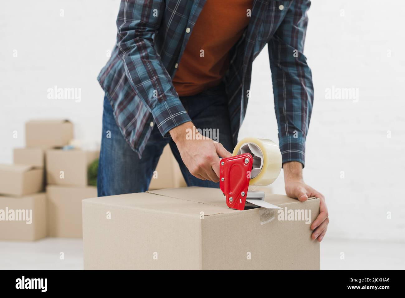 Close up man sealing cardboard box with duct tape. High quality