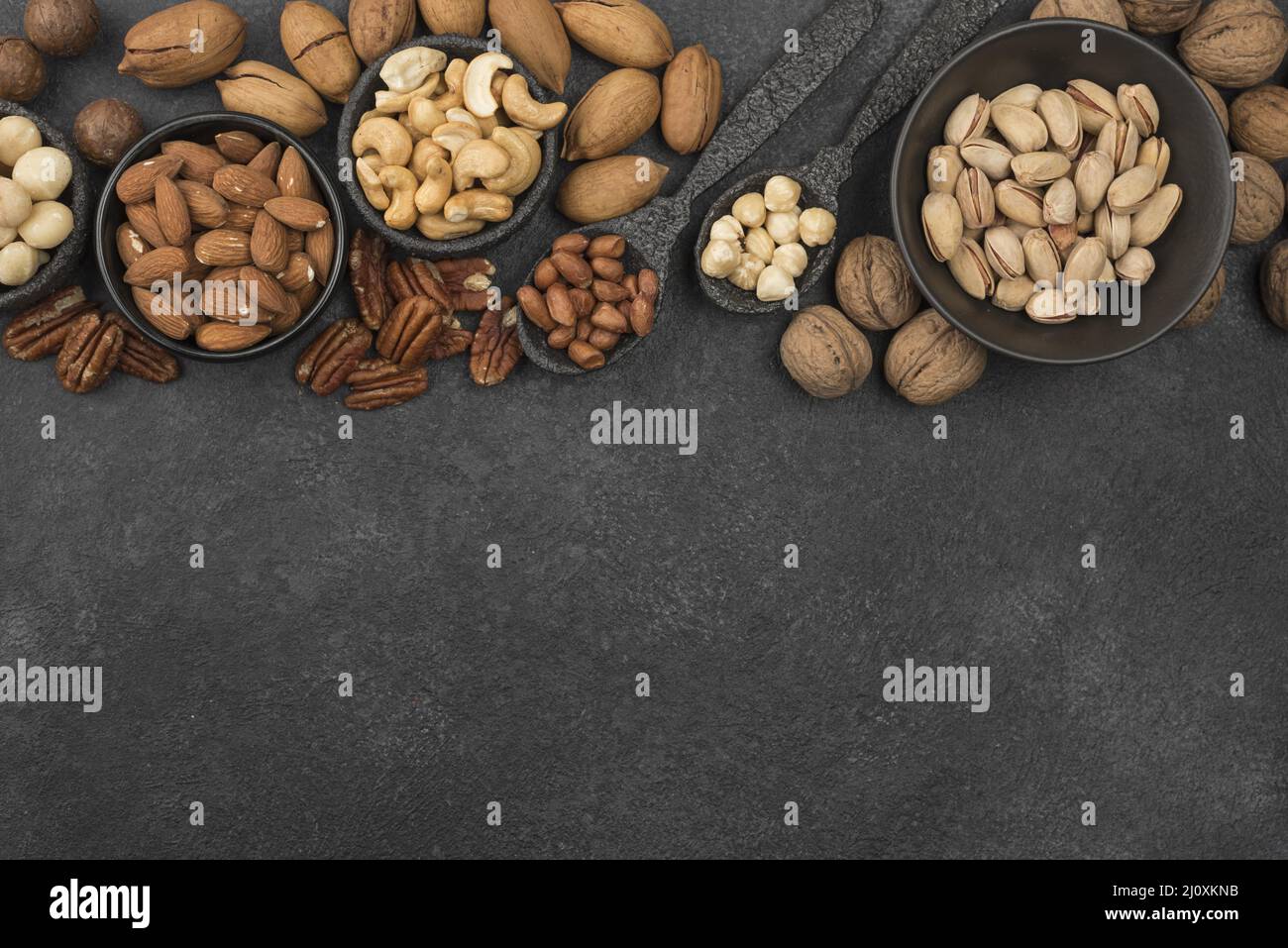 Different kinds nuts dark copy space background. High quality beautiful photo concept Stock Photo