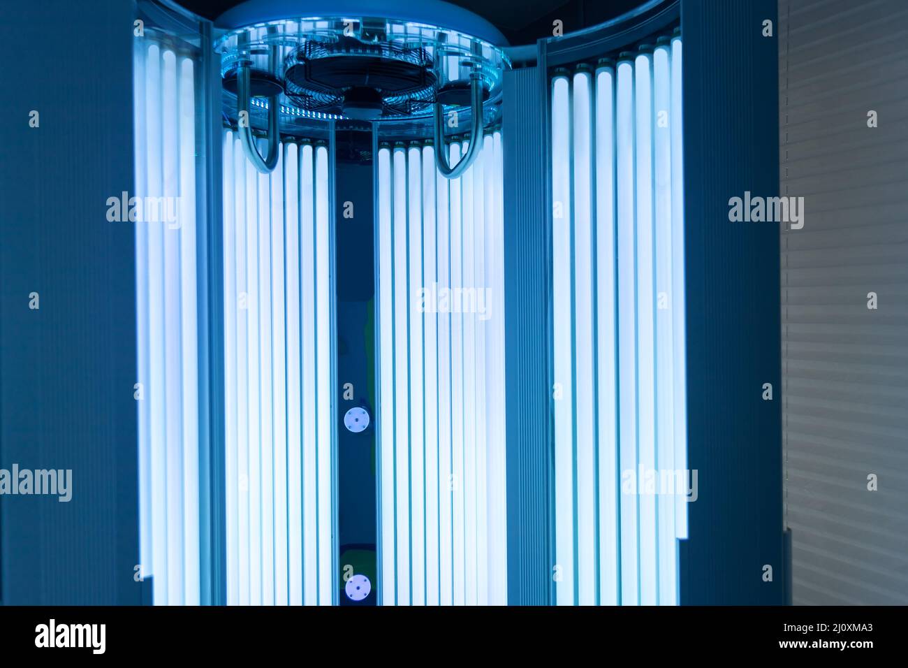 Close up of vertical solarium for tanning skin in spa salon, ultraviolet rays color Stock Photo