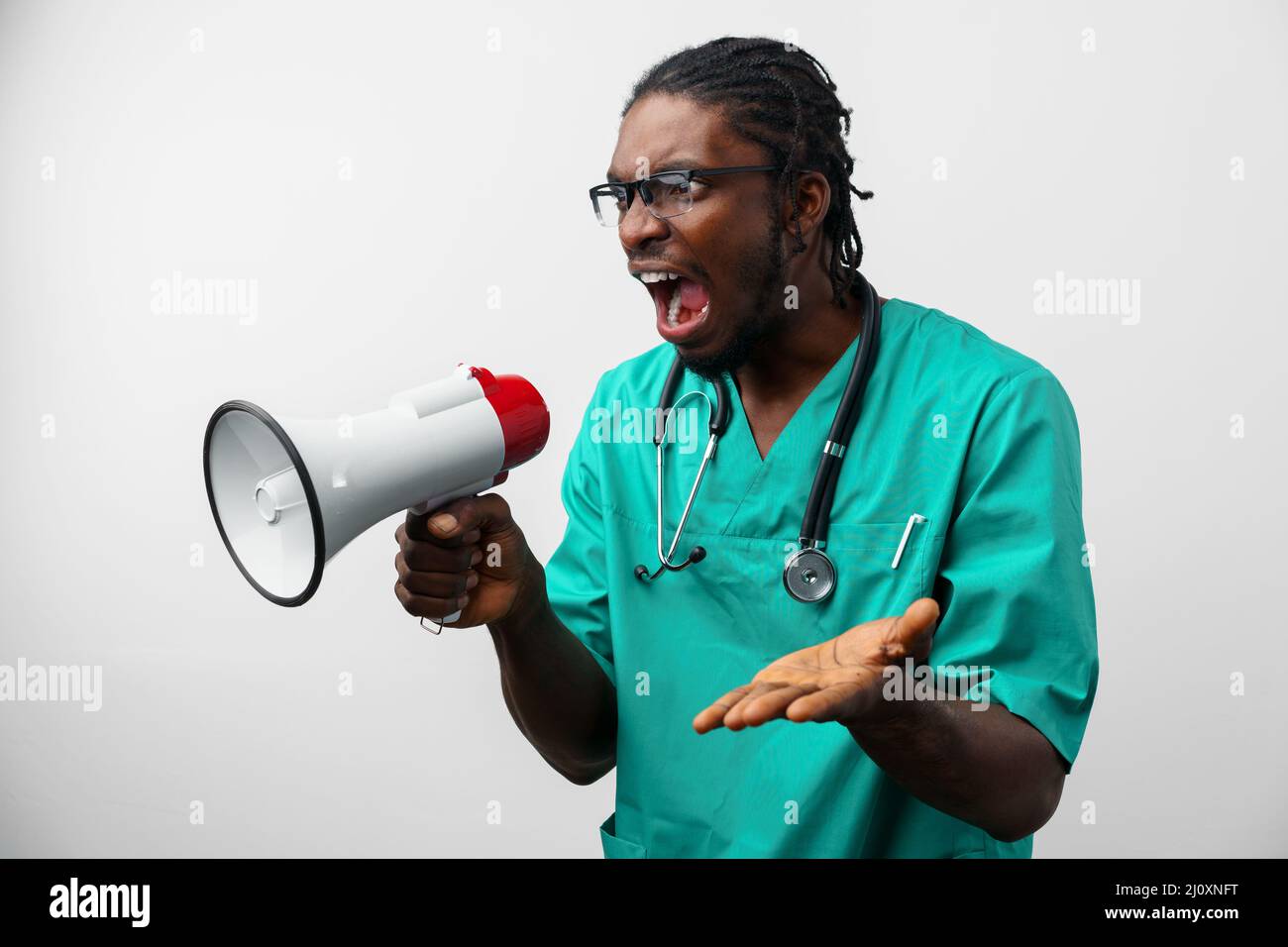 Young black doctor in green uniform using speaker. Stock Photo