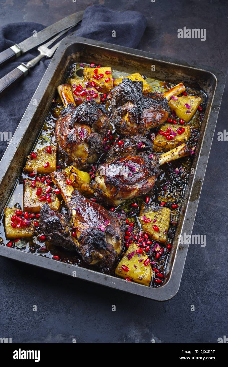 Traditional braised slow cooked Australian lamb shank with pineapple and pomegranate served as close-up in a backing form Stock Photo