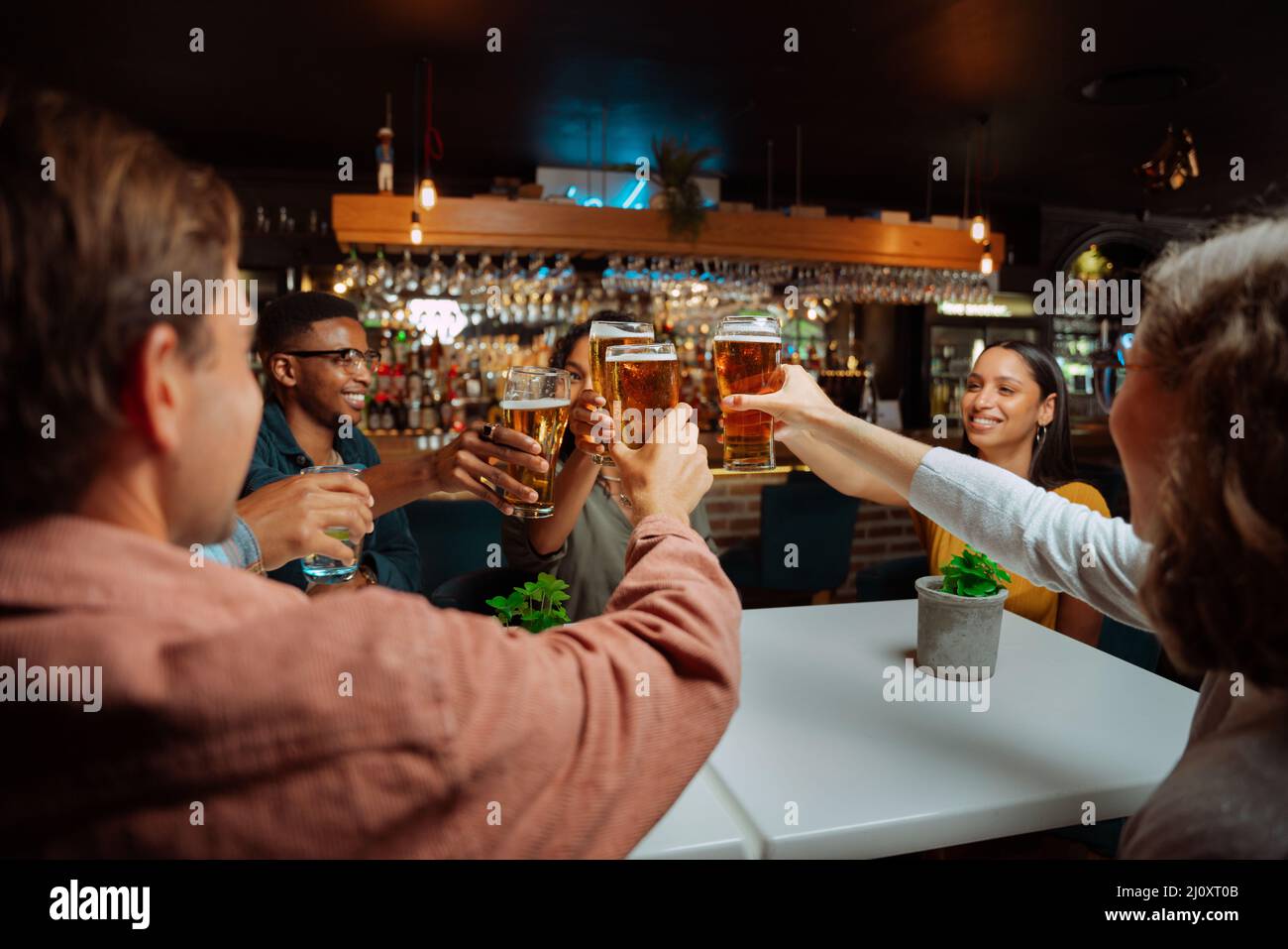 Diverse group of friends making a toast while at dinner Stock Photo
