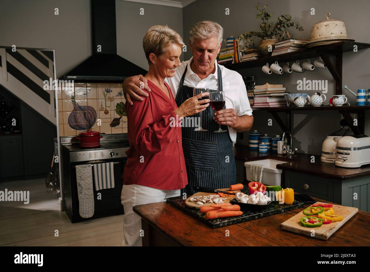 Caucasian senior couple drinking wine in kitchen Stock Photo