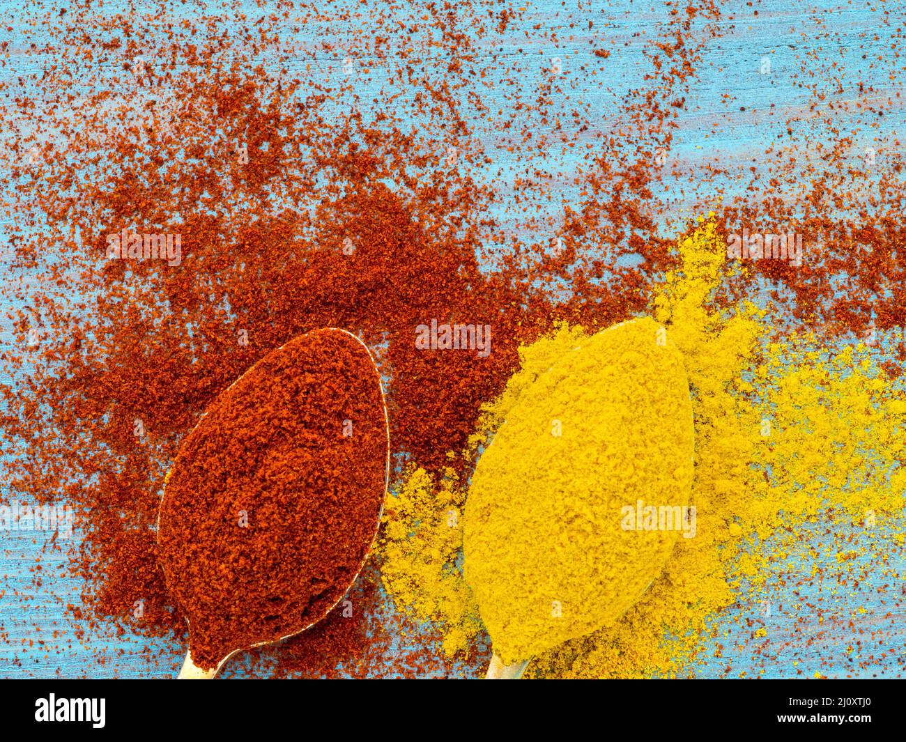 Two heaping scoops of spices of paprika powder and turmeric, curry