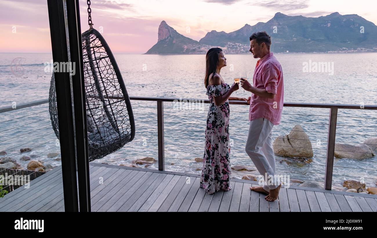 Couple man and woman drinking coffee during on balcony sunrise at