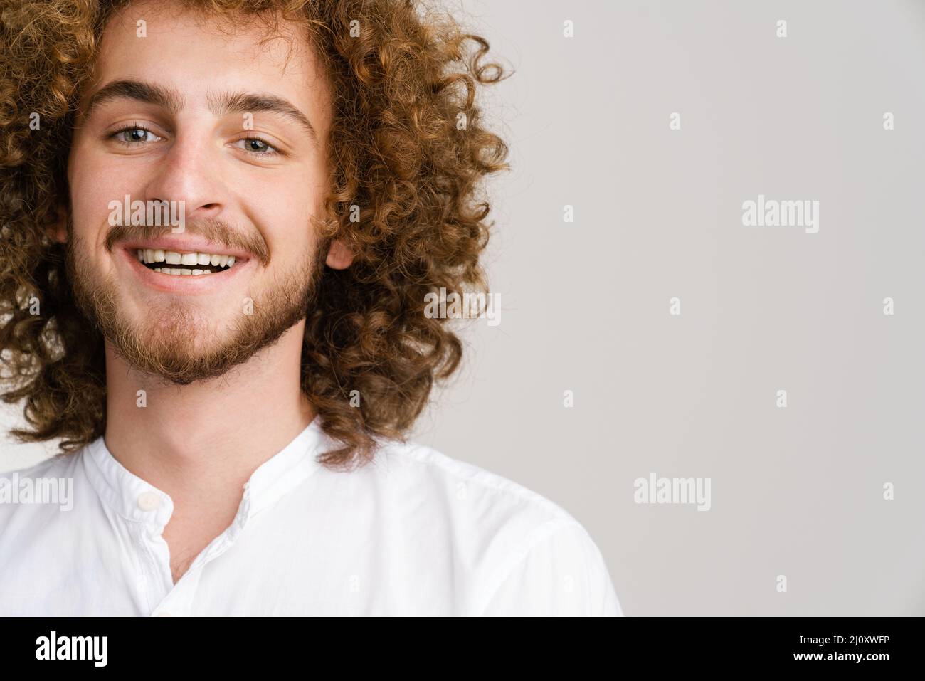 Young curly man with ginger hair smiling and looking at camera isolated  over white background Stock Photo - Alamy