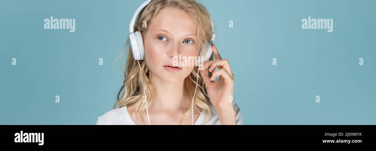 Long width banner with portrait of young woman listening music via headphones Stock Photo