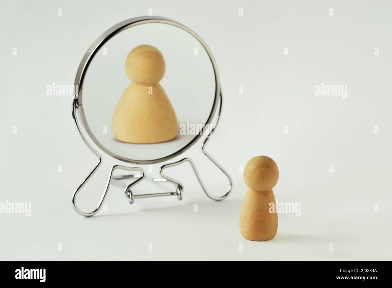 Small pawn looking in the mirror and seeing itself fat - Concept of dysmorphobia, anorexia, distorted self-image Stock Photo