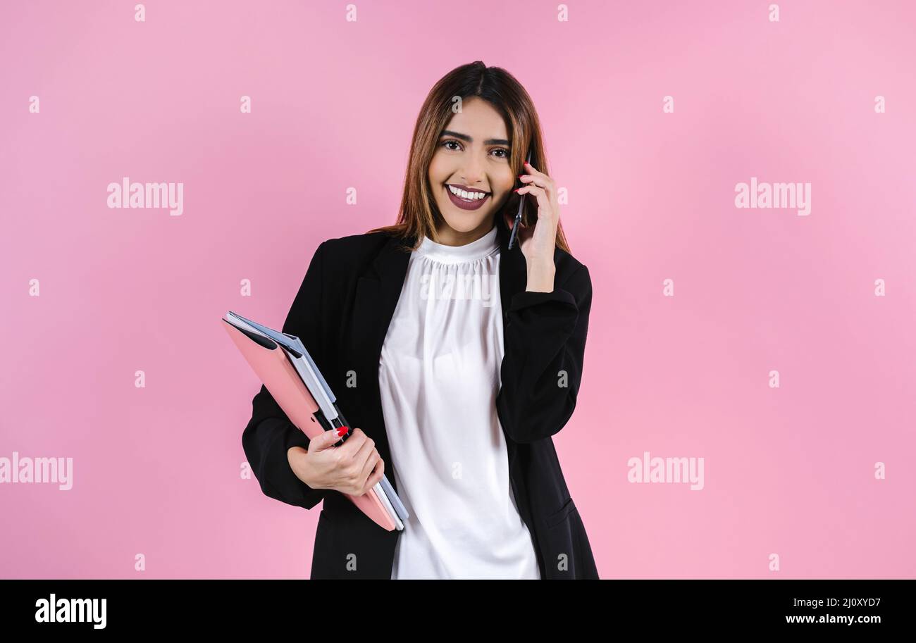 young hispanic business woman portrait smiling at camera on pink background in Mexico Latin America Stock Photo