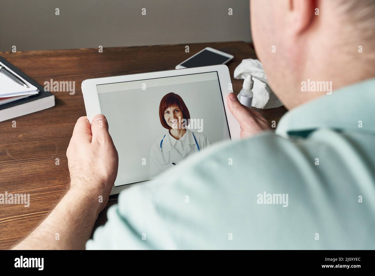 Man looks at tablet, video call to doctor, communication with doctor ...
