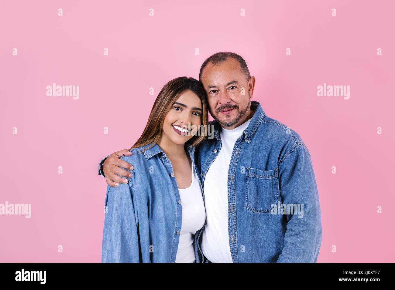latin father and daughter in casual clothes in a copy space on pink background in Mexico Latin America Stock Photo