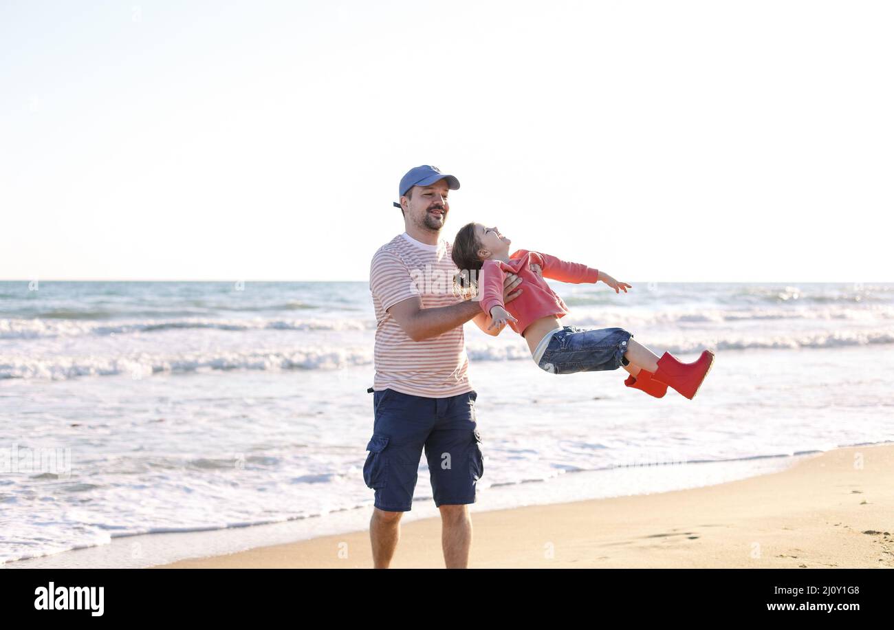 Father playing with his little daughter on sea beach Stock Photo