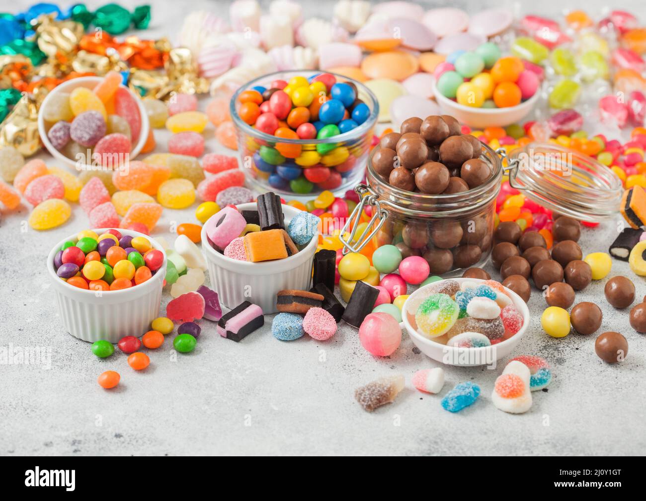 Milk chocolate candies woth shell in jar with various jelly gums