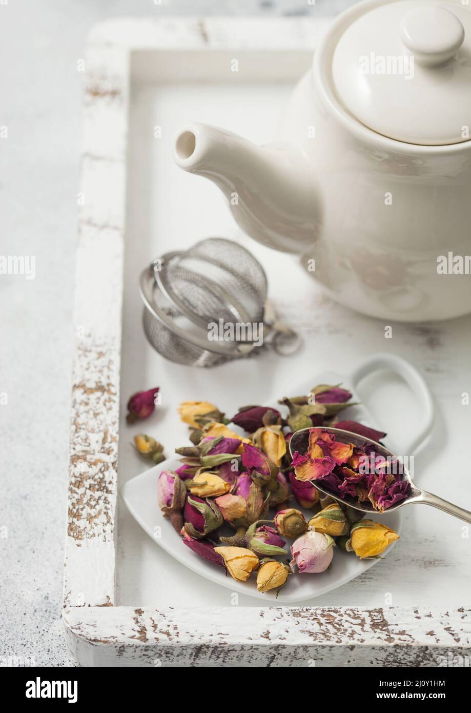 Rose buds mix tea on cup shape ceramic plate and tea ball strainer infuser  and ceramic teapot in white wooden box. Macro Stock Photo - Alamy